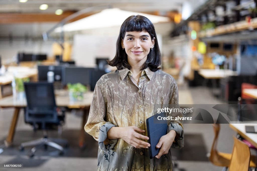 Portrait of a confident young woman standing at makers space