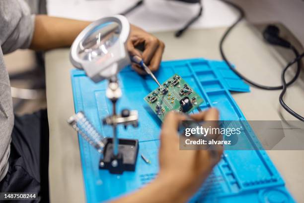 close-up of a man welding a circuit board in workshop - resistencia electrica imagens e fotografias de stock