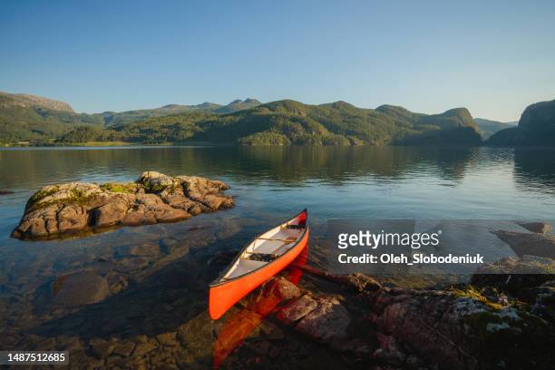 scenic view of red canoe on the lake in norway - rondane national park stock pictures, royalty-free photos & images