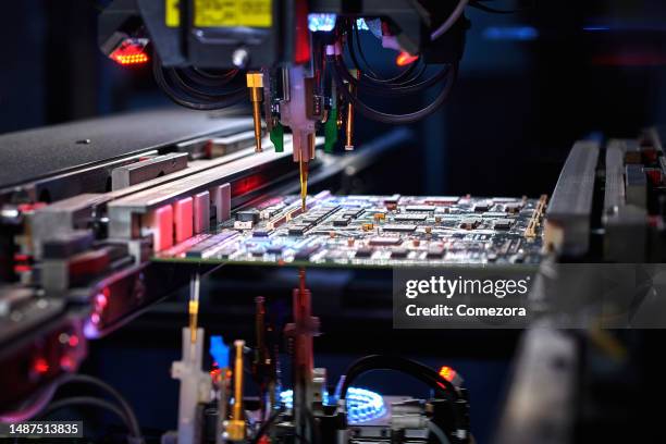 robotic arm installing component at circuit board - chip stock pictures, royalty-free photos & images