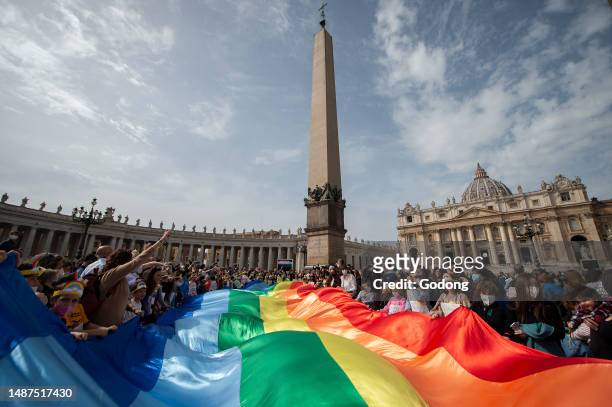 Children hold a rainbow flag as Pope Francis speaks to the crowd during his Angelus prayer from the window of the apostolic palace overlooking St...