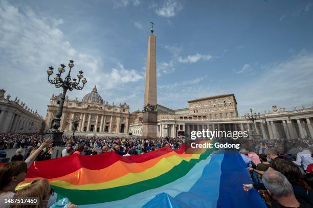 Children hold a rainbow flag as Pope Francis speaks to the crowd during his Angelus prayer from the window of the apostolic palace overlooking St...