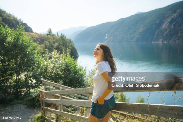 woman standing near the stairs that lead to the fjord - geiranger stock pictures, royalty-free photos & images