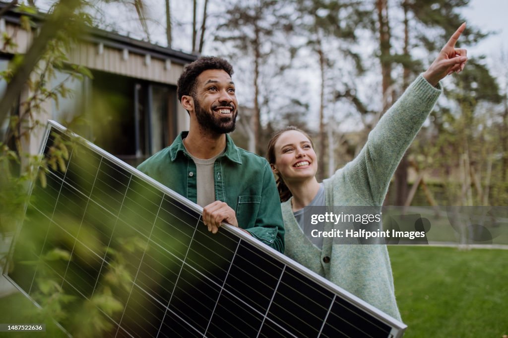 Happy couple posing with solar panel.