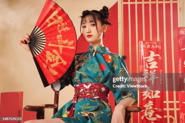 young woman with a fan in the new year - the cheongsam photos et images de collection