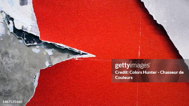 close-up of gray and red posters peeled and torn on a concrete wall in paris, france - panfleto-documento fotografías e imágenes de stock