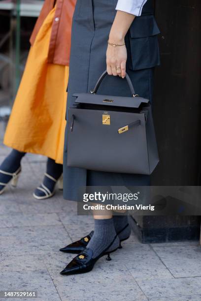 Aliya Bermukhambetova wears Hermes bag, white cropped Miu Miu button shirt, high waisted skirt, grey socks, loafers, sunglasses at VISA Fashion Week...