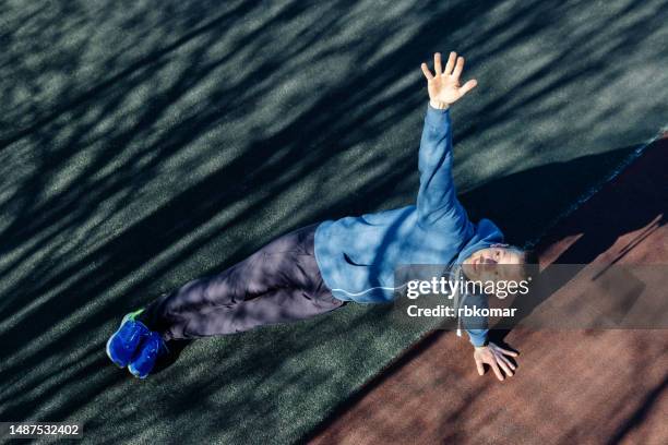side plank pose - man doing a workout on the muscles of the core on the sports field in the park - core stock pictures, royalty-free photos & images