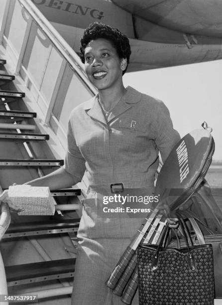 American tennis player and reigning Wimbledon Champion Althea Gibson descends the steps of a plane at London Airport to write about the upcoming...