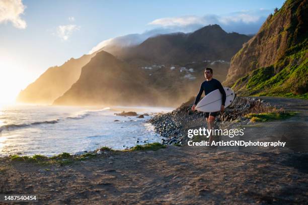 surfer walking on a beautiful beach at sunrise. - prancha de surf imagens e fotografias de stock