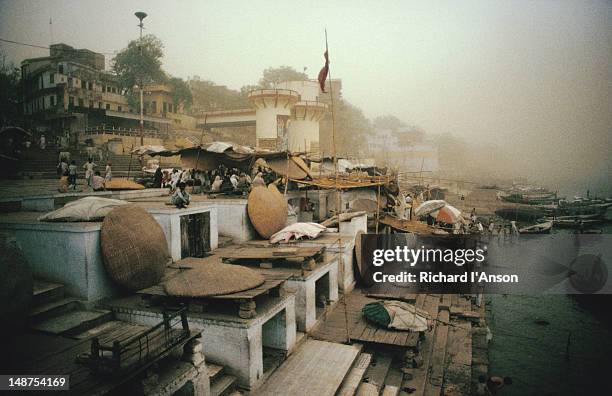 a mid-afternoon sandstorm engulfs the bathing ghats on the ganges river at varanasi - engulfs stock pictures, royalty-free photos & images