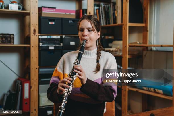 a woman is playing clarinet for practice - klarinet stockfoto's en -beelden