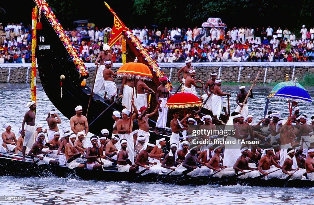 Snake boats in pre-race procession on Pampa River River during Onam festival celebrations.