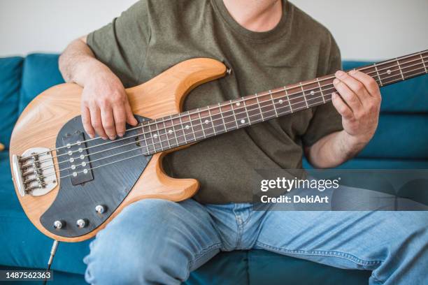 unrecognizable male guitarist playing bass guitar at home - instrumento-baixo imagens e fotografias de stock