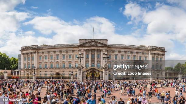 Tourists outside Buckingham Palace in London after gathering to watch the Changing of the Guard ceremony.