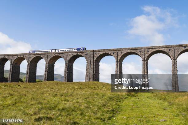 Train passes over the dramatic Ribblehead Viaduct on the Settle to Carlisle railway over the Ribble Valley.