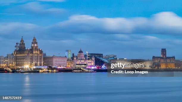 The Liverpool waterfront begins to light up during the blue hour on New Years day in 2022.
