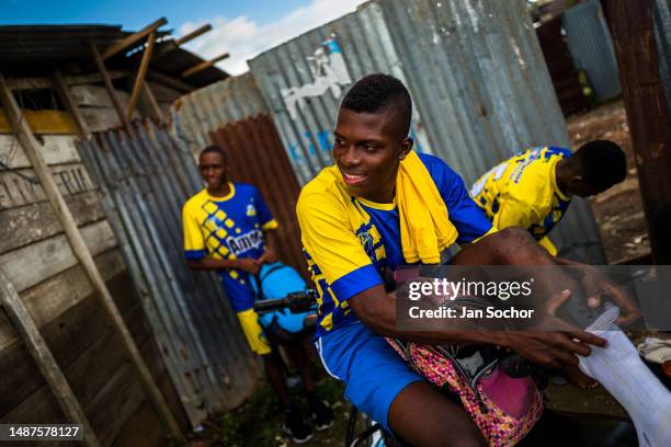 Young Afro-Colombian football put on their gear next to the dirt playing field before a match on October 10, 2019 in Quibdó, Chocó, Colombia. Young...