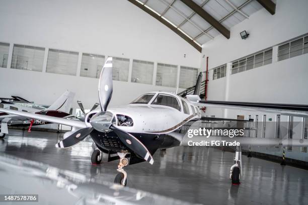 private airplane in the airport hangar - civil aviation stock pictures, royalty-free photos & images