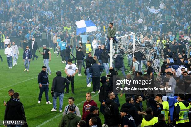 Napoli fans are seen on the pitch after their side wins the Seria A title after the Serie A match between Udinese Calcio and SSC Napoli at Dacia...