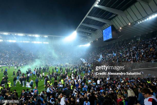 Napoli fans are seen on the pitch after their side wins the Seria A title after the Serie A match between Udinese Calcio and SSC Napoli at Dacia...