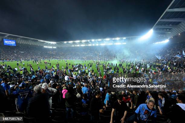 Napoli fans are seen on the pitch after their side wins the Seria A title after the Serie A match between Udinese Calcio and SSC Napoli at Dacia...