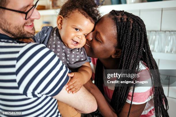 authentic moment between parents and baby - real family stock pictures, royalty-free photos & images