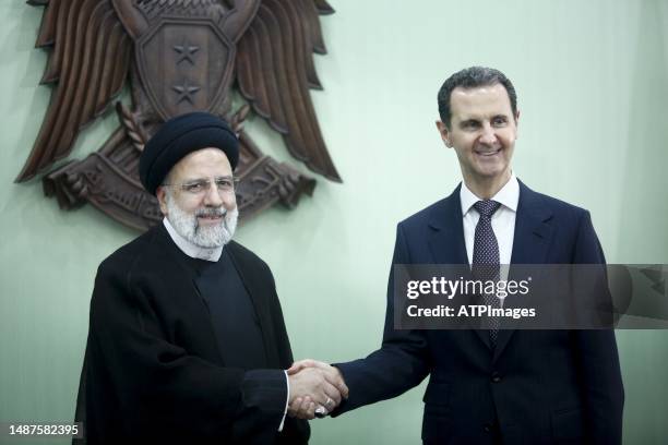 Syria's President Bashar al-Assad, and Iranian counterpart Ebrahim Raisi exchange documents after signing a memoranda of understanding on "long-term...