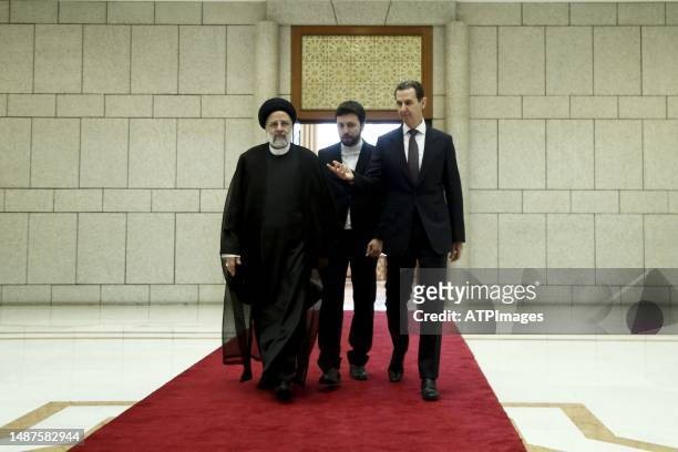 Syria's President Bashar al-Assad, and Iranian counterpart Ebrahim Raisi exchange documents after signing a memoranda of understanding on "long-term...