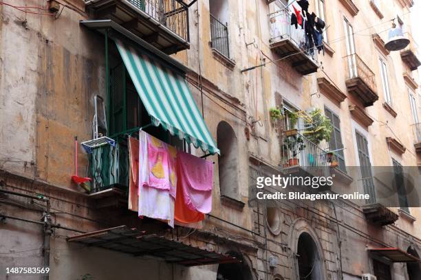 Laundry hanging to dry on a line on the wall of a morbid apartment building in the historic center of Naples, Campania, Italy.