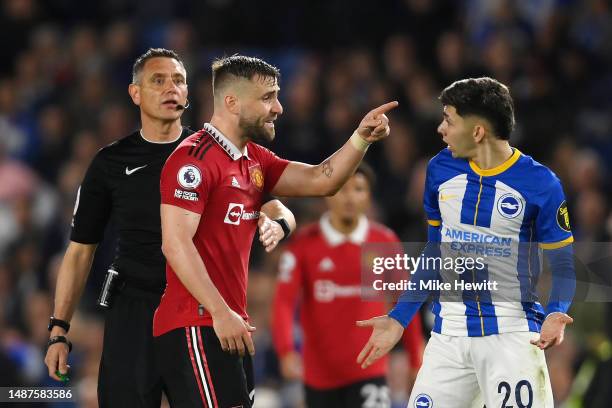 Luke Shaw of Manchester United and Julio Enciso of Brighton & Hove Albion react before a VAR check for handball which results in a penalty being...