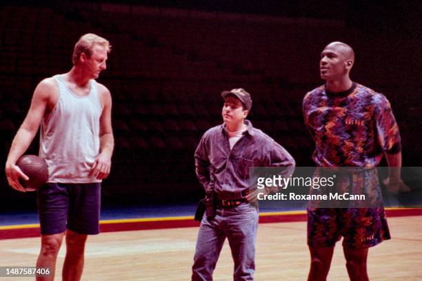 Award-winning basketball players former Boston Celtics Larry Bird and Chicago Bulls Michael Jordan stand on either side of a production team member...