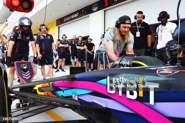 Andrew Van Ginkel tries his hand at changing a wheel as the Red Bull Racing team practice pitstops during previews ahead of the F1 Grand Prix of...