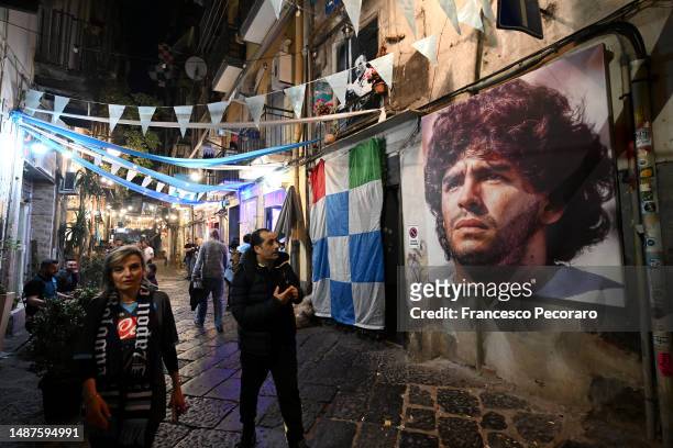 Mural of Diego Maradona is seen in the city centre as fans of SSC Napoli celebrate their side winning the Serie A title after their side's draw in...