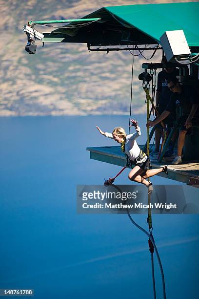 woman leaping from the ledge bungee. - bungee jump stockfoto's en -beelden