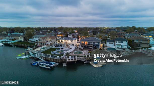 wealthy neighborhood in a small town on sea channel with luxury boats. oceanside, new york, aerial panoramic view - hempstead imagens e fotografias de stock