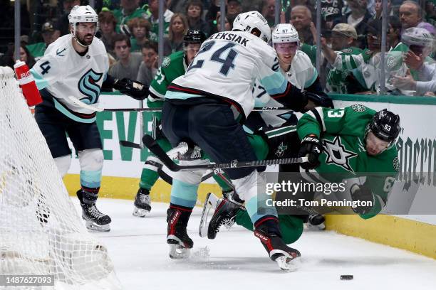 Jamie Oleksiak of the Seattle Kraken checks Evgenii Dadonov of the Dallas Stars into the boards in the first period in Game Two of the Second Round...