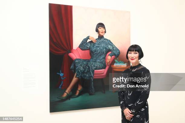 Claudia Chan Shaw poses alongside Sally Ryan's portrait of her titled 'Year of the Rabbit' at Art Gallery Of NSW on May 05, 2023 in Sydney,...