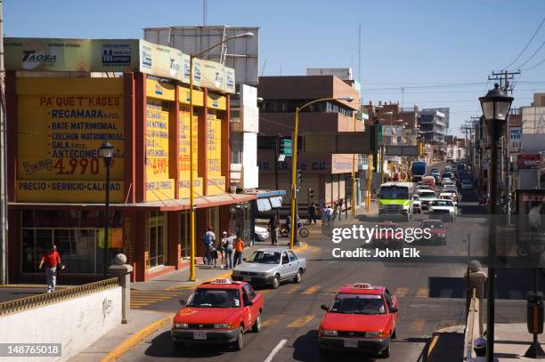 downtown street scene with red taxis. - aguas calientes stock pictures, royalty-free photos & images