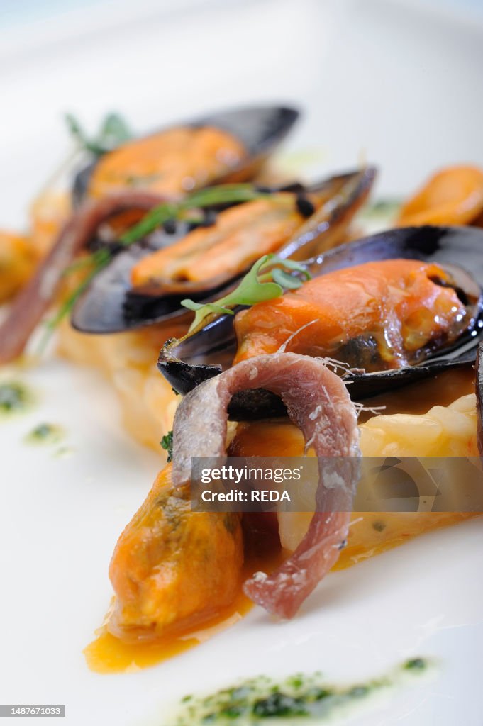 Muscles Risotto A dish of tomato risotto garnished with mussels and anchovies. News ...