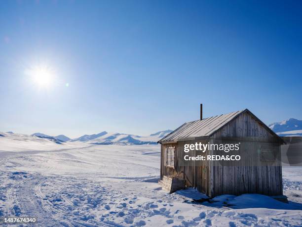 Traditional hut at frozen Groenfjorden, Island of Spitsbergen, part of Svalbard archipelago. Arctic region, Europe, Scandinavia, Norway, Svalbard.