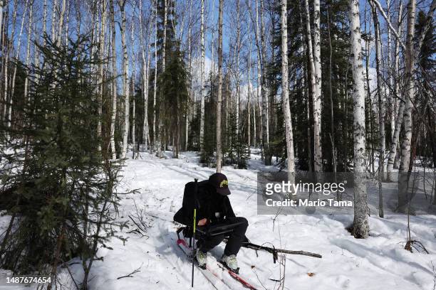 SnowEx researcher Dr. Kelly Gleason works on skis while taking measurements of snow albedo in a section of boreal forest during the melt season on...