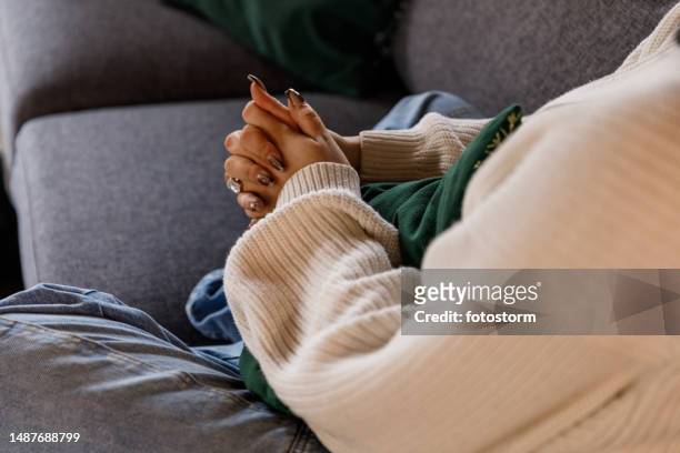 young woman struggling with negative emotions and anxiously cracking her knuckles - knuckle stock pictures, royalty-free photos & images