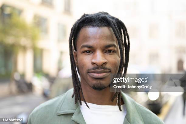 headshot portrait of mid adult black man in city street - street stock pictures, royalty-free photos & images