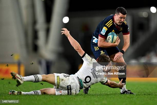 Freddie Burns of the Highlanders steps inside of Brad Weber of the Chiefs during the round 11 Super Rugby Pacific match between Highlanders and...