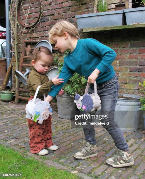 children searching for eggs - easter basket with candy stock pictures, royalty-free photos & images