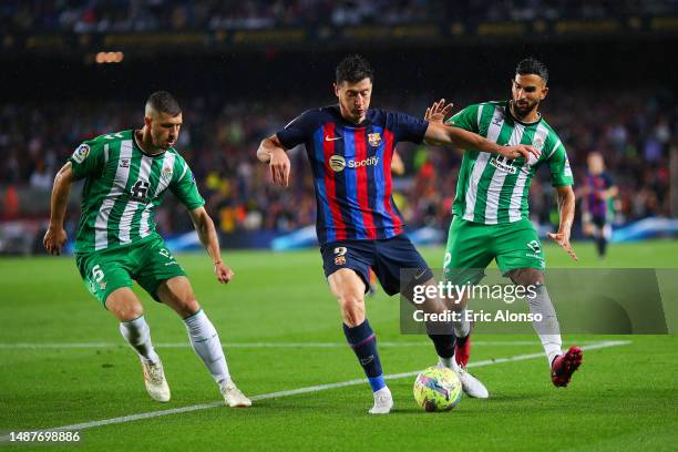 Robert Lewandowski of FC Barcelona is tackled by Martin Montoya and Guido Rodriguez of Real Betis during the LaLiga Santander match between FC...