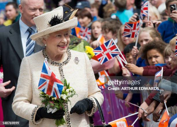 Britain's Queen Elizabeth II is greeted by flag-waving well-wishers as she visits the City Varieties Music Hall in Leeds, West Yorkshire, northern...