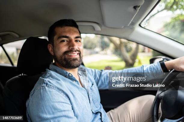 portrait of a young man driver in a car - taxichauffeur stockfoto's en -beelden