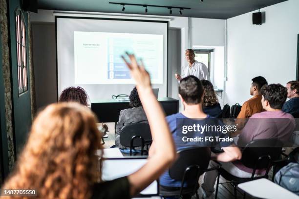 student with hand raised to ask something during class - classroom projector screen stock pictures, royalty-free photos & images